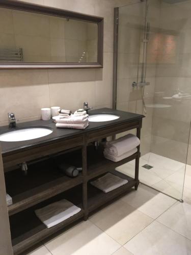 ein Badezimmer mit zwei Waschbecken und einer Dusche in der Unterkunft Le Prince Gourmand in Echinghen