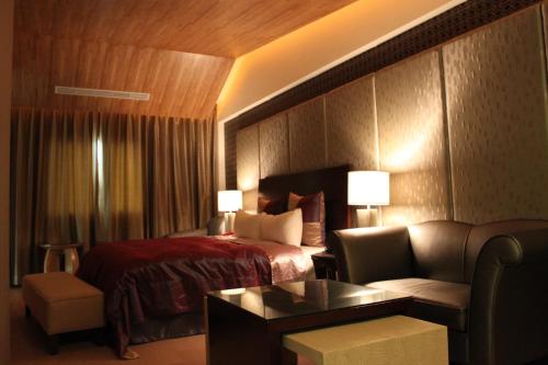 een hotelkamer met een bed en een bank bij Milan Motel in Miaoli