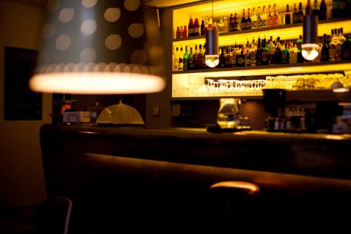 a bar with a shelf with liquor bottles at Gasthaus zum Guten Glück in Zurich