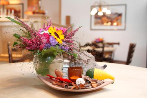 a vase with flowers in it on a table at Posthotel Usseln in Willingen