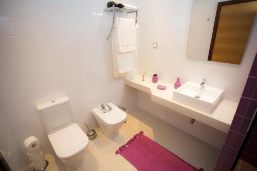 Un baño blanco con inodoro y lavabo. en Surf and Stones Apartment, en Peniche