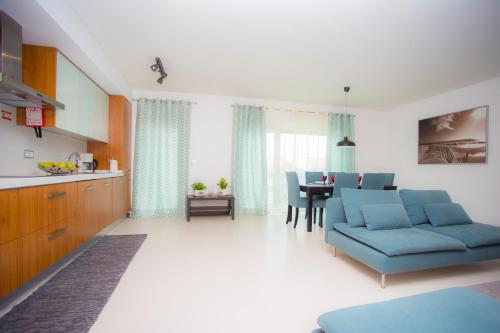 a living room with a blue couch and a table at Surf and Stones Apartment in Peniche
