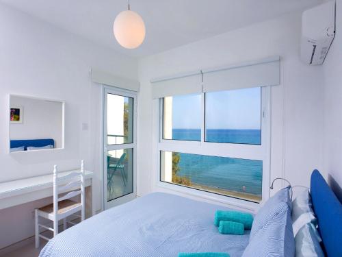 a bedroom with a bed and a view of the ocean at On The Beach Penthouse by TrulyCyprus in Limassol
