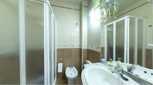 Un baño con ducha, lavabo e inodoro. en Casas Rurales Carroyosa del Jerte, en Navaconcejo