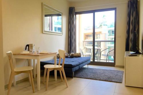 a living room with a table and a blue couch at Unixx by 4Poolvillas in Pattaya South