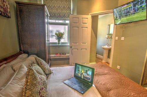 a laptop computer sitting on a bed in a room at Dunster Castle Hotel in Dunster