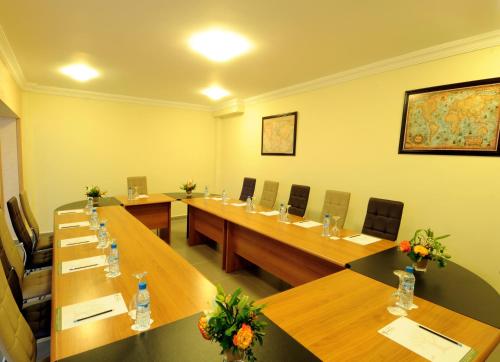 a large meeting room with long wooden tables and chairs at Aparthotel Les Oliviers Suites & Spa in Fès