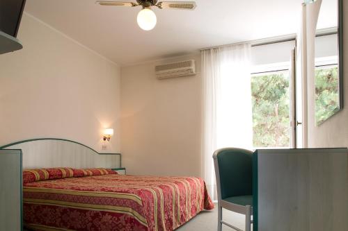 a bedroom with a bed and a window at Hotel San Marco in Lignano Sabbiadoro