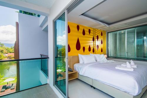 a bedroom with a bed and a large window at The Peak in Chanthaburi