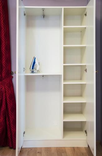 a closet with white doors and shelves at Design Apartment Havelska in Prague