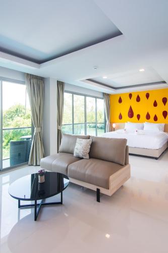 a living room with a couch and a bed at The Peak in Chanthaburi