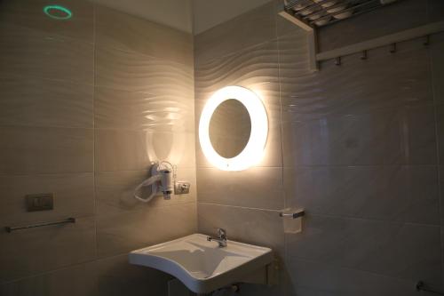 a bathroom with a sink and a round mirror at Ville Vesuviane in San Giorgio a Cremano