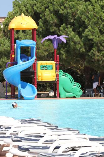a swimming pool with a playground and a slide at Club Esse Gallura in Aglientu