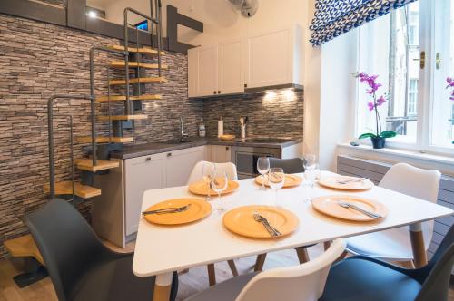 a dining room with a white table and chairs at Design Apartment Havelska in Prague