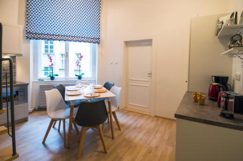 a kitchen and dining room with a table and chairs at Design Apartment Havelska in Prague