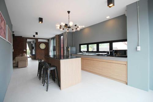 une cuisine avec un bar avec des chaises noires dans l'établissement Unique Loft Apartment, à Kamala Beach