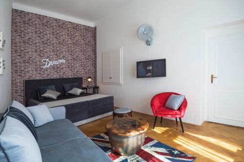 a living room with a couch and a red chair at Design Apartment Havelska in Prague