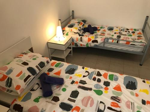 two twin beds in a bedroom with a bedspread with cows on it at Swieqi Semi Detached Maisonette in St Julian's