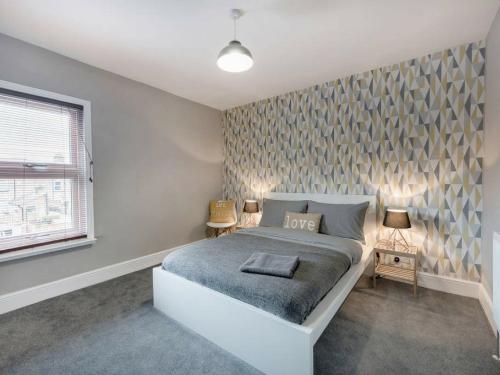 a bedroom with a bed with a love wall at Cambridge House in Luton