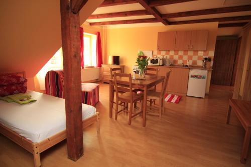 a living room with a table and a kitchen at Stara Mlekarna in Kytlice