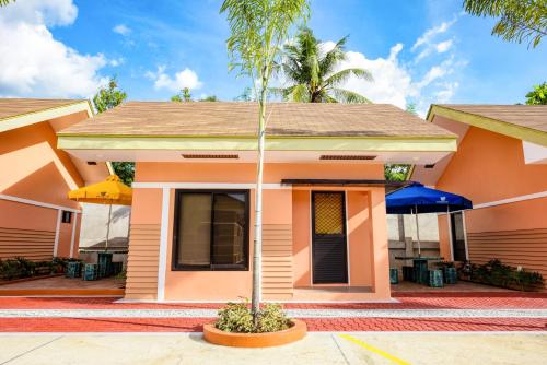 a small house with a palm tree in front of it at Kabaleyan Cove Resort powered by Cocotel in San Carlos