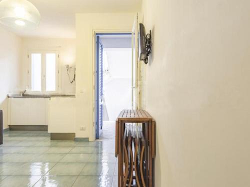 WeLive Marettimo - luxury loft في ماريتيمو: مطبخ بجدران بيضاء وطاولة في الغرفة