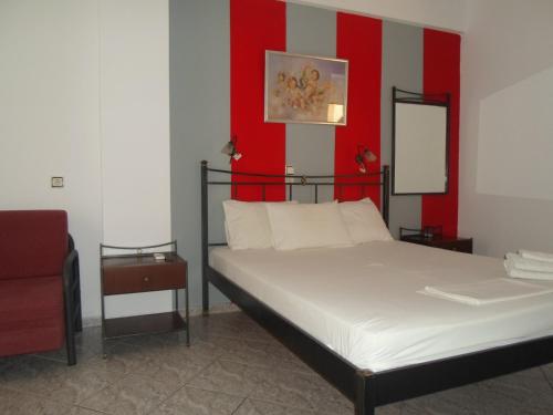 a bedroom with a bed with a red wall at Costareli in Fourni Ikarias