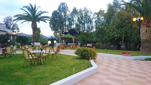 a patio with chairs and tables in a park at Il Complesso Saraceno in Torre delle Stelle
