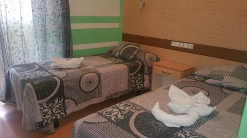 a room with two beds with white animals on them at Hostal Lima in Valladolid