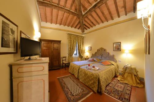 a bedroom with a bed and a flat screen tv at Villa Borgo San Pietro in Cortona