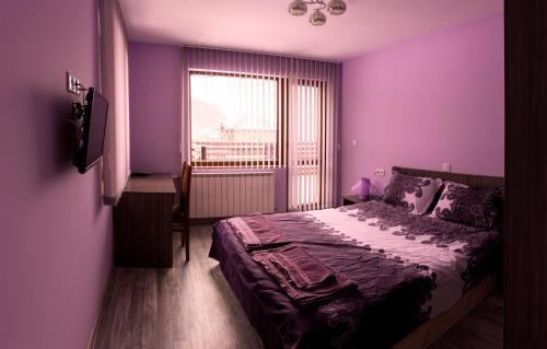 une chambre violette avec un lit et une fenêtre dans l'établissement Kavdanski Guesthouse, à Sapareva Banya