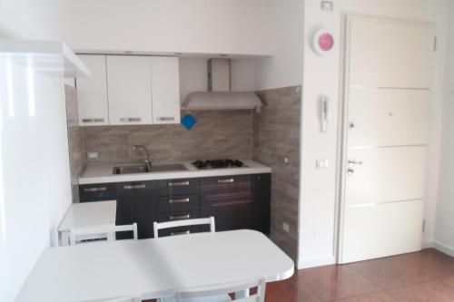 een keuken met witte kasten, een wastafel en een fornuis bij DIMORA Simona in Caorle