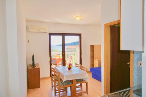 a living room with a table and a view of a balcony at Apartment Mar y amore in Seget Vranjica