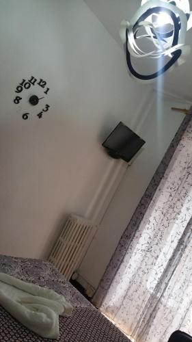 a bedroom with a bed and a clock on the wall at Hostal Lima in Valladolid