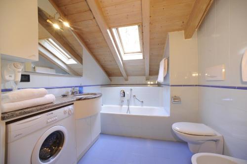 a bathroom with a washing machine and a tub at Residence Lagorai - Fiemme Holidays in Predazzo