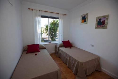 een kamer met twee bedden en een raam bij Villa Benita in Playa Blanca
