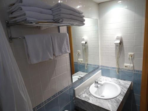 La salle de bains est pourvue d'un lavabo, d'un miroir et de serviettes. dans l'établissement Apartamentos Selvapark, à Lloret de Mar