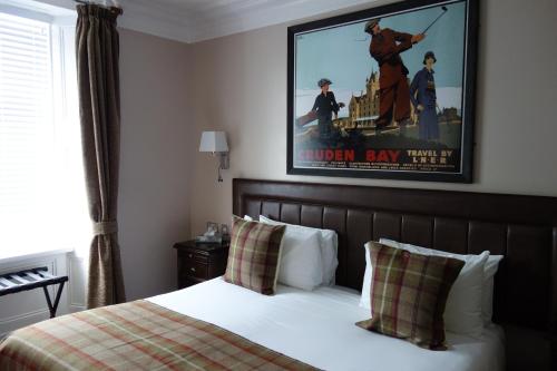 a hotel room with a bed with a poster of a movie at Kilmarnock Arms Hotel in Cruden Bay