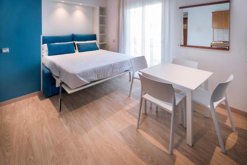 a room with a bed and a table and chairs at GHT Balmes, Hotel-Aparthotel&SPLASH in Calella