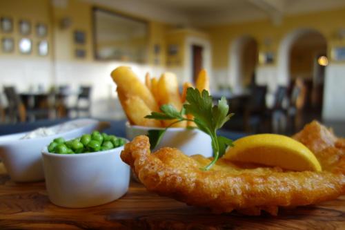a plate of food with fish and chips and peas at Kilmarnock Arms Hotel in Cruden Bay