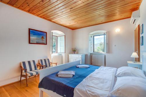 a bedroom with a bed and two chairs at Unique Antistress Oasis Villa Antiqua in Osor
