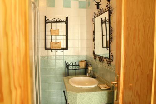 a bathroom with a sink and a mirror at Hostal Zaguan in Talaveruela