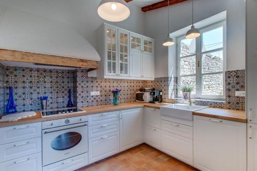 a kitchen with white cabinets and a sink at Unique Antistress Oasis Villa Antiqua in Osor