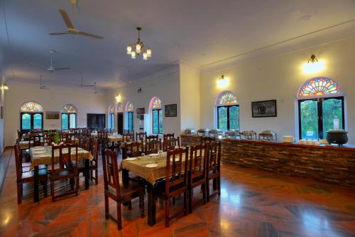 een eetkamer met tafels en stoelen in een restaurant bij Ranthambhore Heritage Haveli in Sawāi Mādhopur