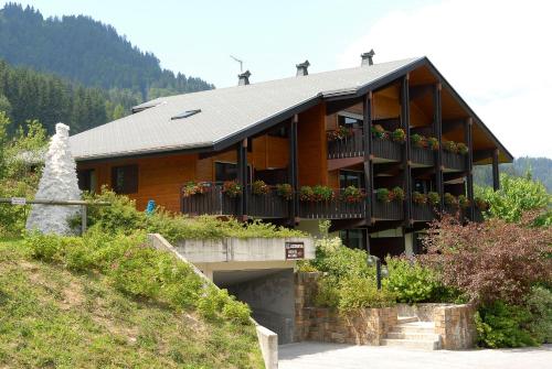 a building with a balcony and flowers on it at Résidence Azureva La Clusaz les Aravis in La Clusaz