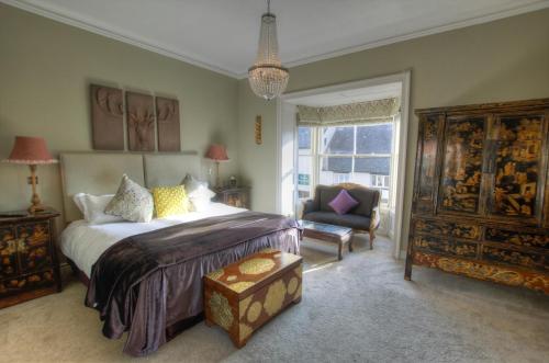 a bedroom with a large bed and a chair at Dunster Castle Hotel in Dunster