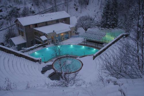 une maison avec une piscine dans la neige dans l'établissement Résidence Campredon - Décoration typique - 25m2 de Terrasse aménagée plein sud avec vue panoramique - Internet - Jardin - Parking - Navette - Linge et Ménage en options payantes, à Font-Romeu