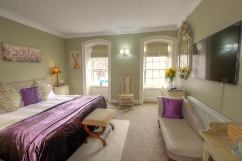 a bedroom with a large bed and a couch at Dunster Castle Hotel in Dunster
