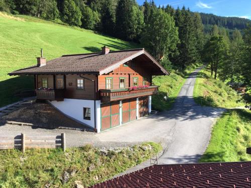 a house on a hill next to a road at Apartment Lehengut in Eben im Pongau