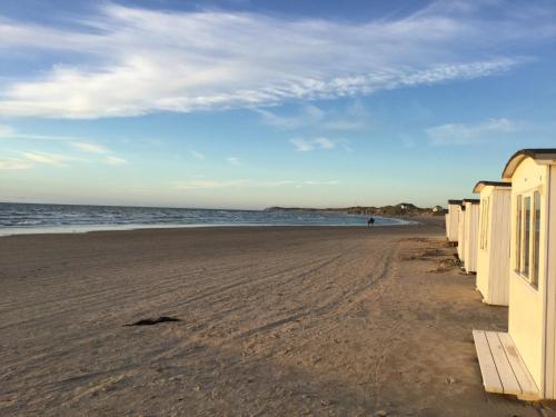 a beach with a building and the ocean at Lucky 3 Apartments in Løkken